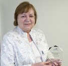 Nancy West holding the President's Award trophy.