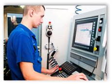 young man looking at computer screen in machine shop