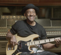 Man holding a guitar and smiling