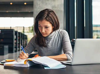 woman student studying at a library
