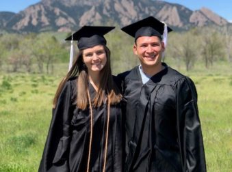 Lana and Josh in their caps and gowns in front of the Flatirons