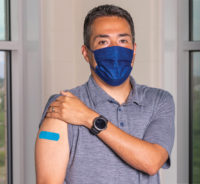 Chico Garcia showing the vaccine band aid on his arm