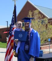 Chris holding his daughter at graduation