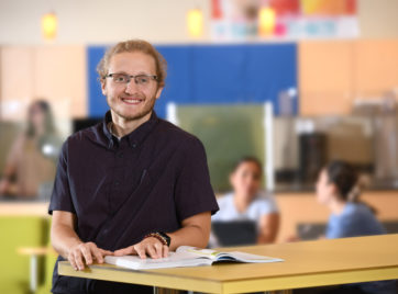 Branden standing at a table at FRCC's Westminster Campus