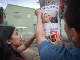 People putting up missing person poster