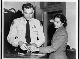 Rosa Parks being fingerprinted by police officer