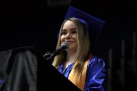 Bianca speaking at the podium at graduation