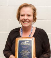 Amy Mann posing with her award plaque