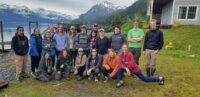 Group of students and faculty in front of mountains and lodge