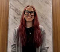 Headshot of Lizzy in glasses smiling