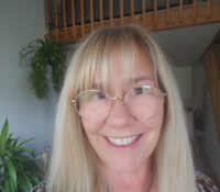 Kristina wearing glasses and smiling at the camera